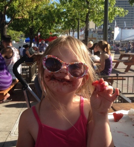 RENO, NV - September 1, 2014: Five-year old Alyssa Dow enjoys a messy chocolate-covered strawberry on the last day of the 26th annual Best in the West Nugget Rib Cook-off. 